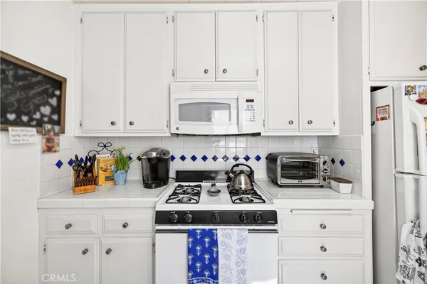 a kitchen with a stove a microwave and cabinets