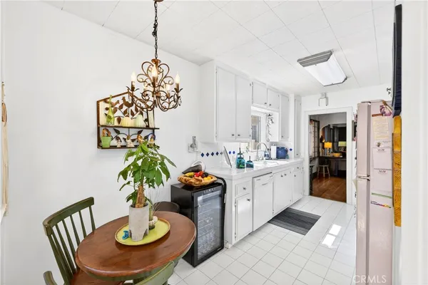 a dining room with furniture a kitchen and chandelier