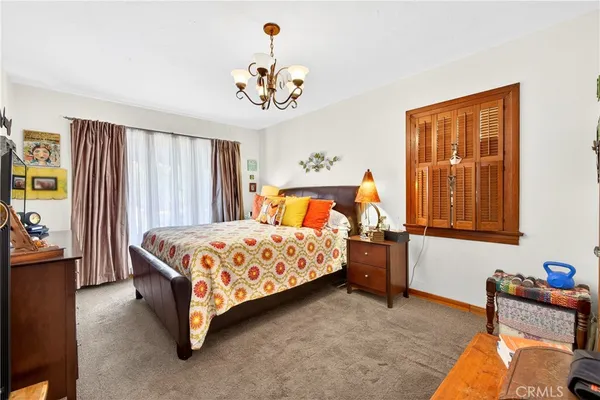 a bedroom with a bed and a chandelier