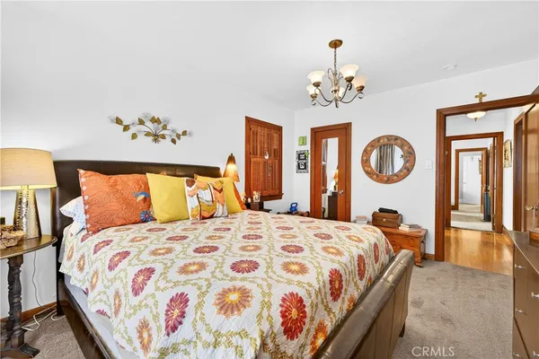 a bedroom with a large bed and a chandelier