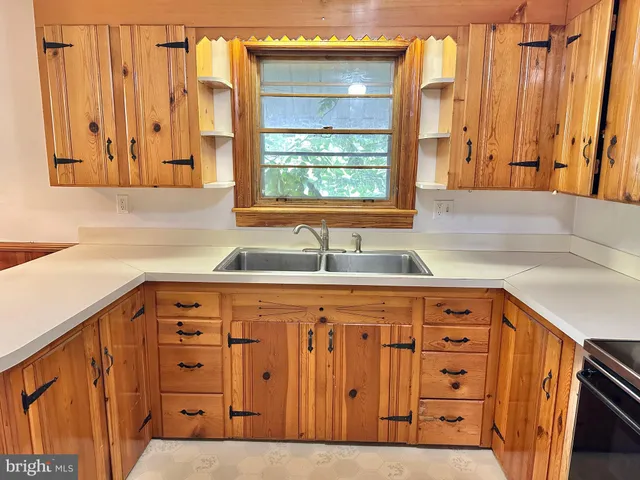 a kitchen with stainless steel appliances a sink and a large window