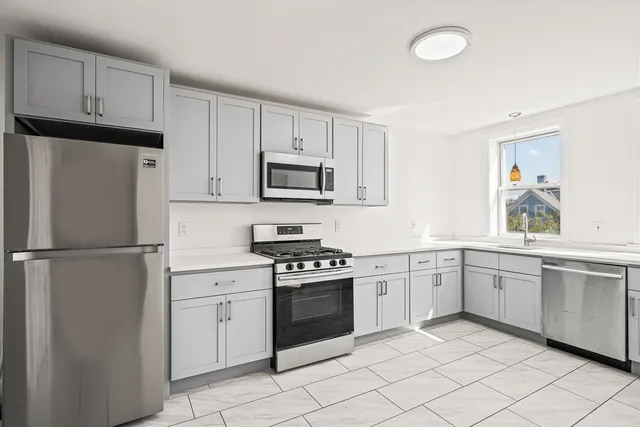 a kitchen with white cabinets and white appliances