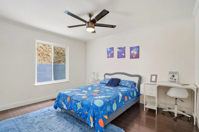 a bedroom with a bed a table and chair