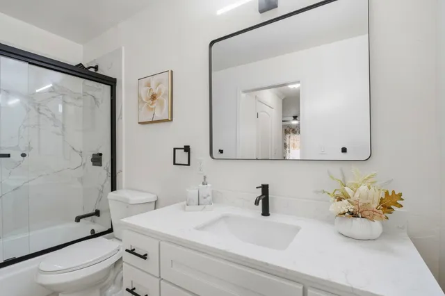 a bathroom with a sink a toilet and shower