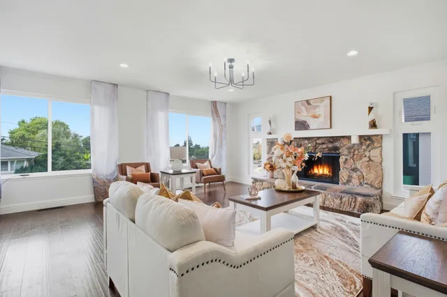 a living room with furniture fireplace and a large window