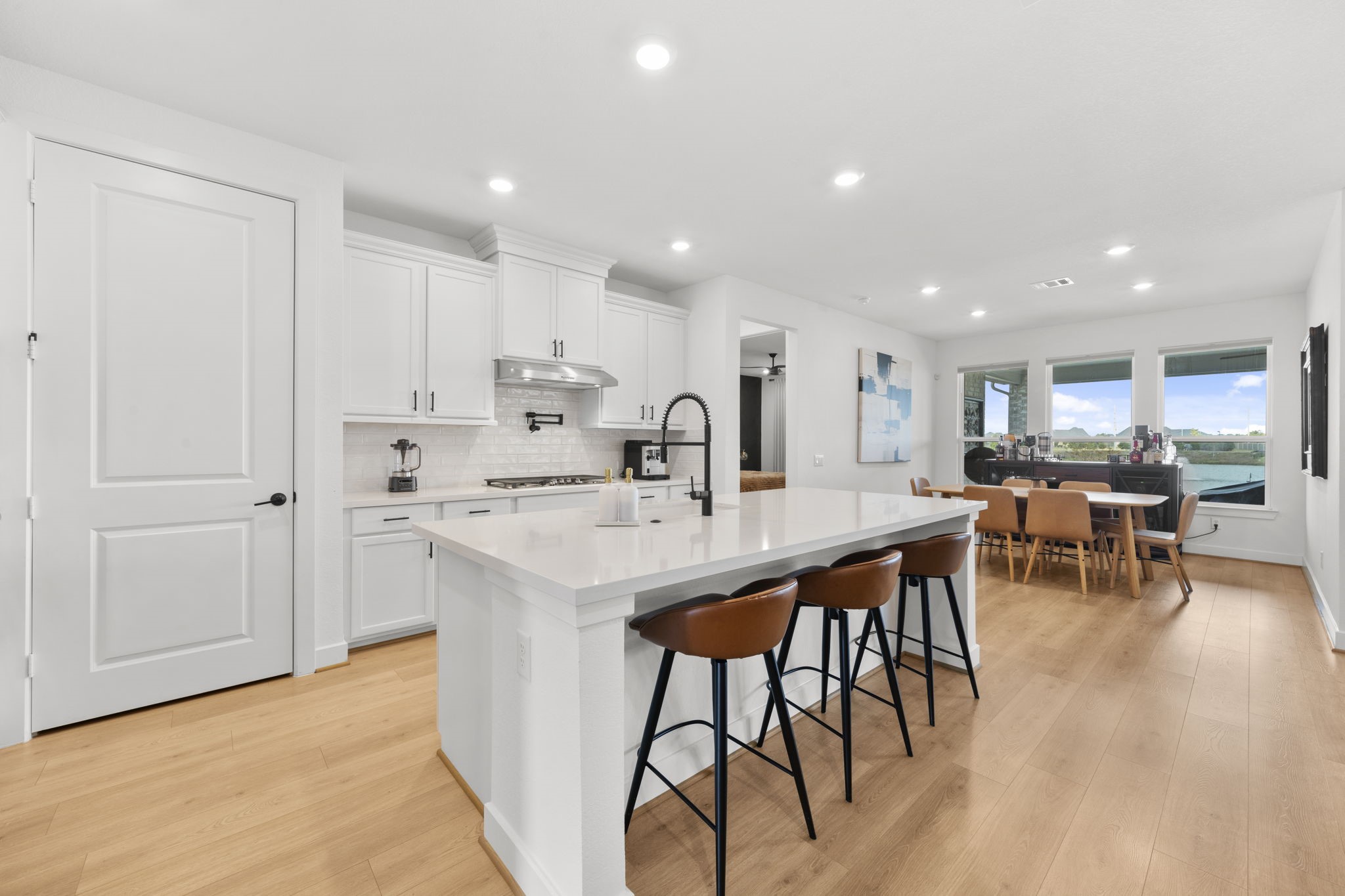 29154 Rustic Orch Lane Fulshear, TX 77441 - Photo 14 of 35 a kitchen with stainless steel appliances kitchen island granite countertop a table chairs sink and cabinets