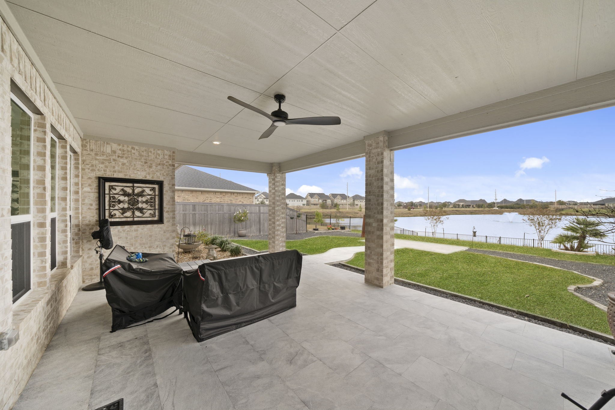 29154 Rustic Orch Lane Fulshear, TX 77441 - Photo 33 of 35 a living room with furniture floor to ceiling window next to a yard