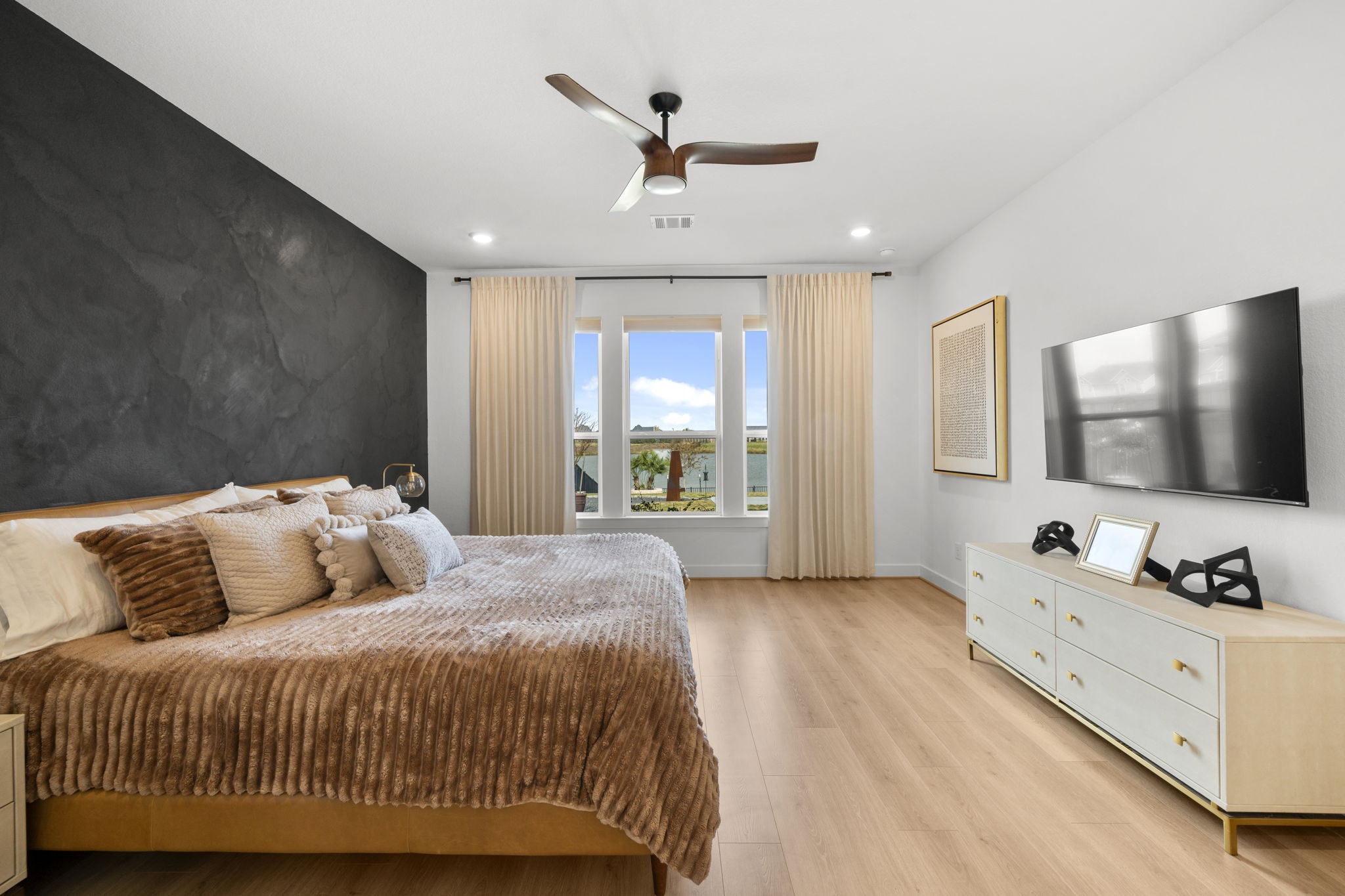 29154 Rustic Orch Lane Fulshear, TX 77441 - Photo 8 of 35 a bedroom with a large bed a flat screen tv and a dresser