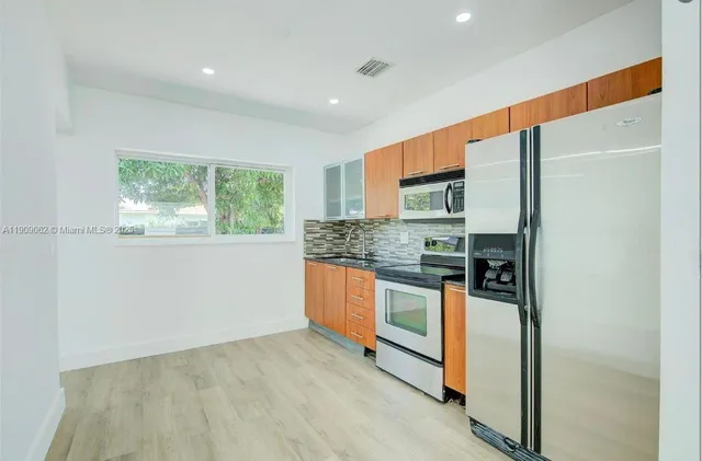 a kitchen with stainless steel appliances granite countertop a refrigerator and a stove