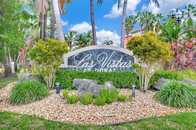 a sign that is sitting in front of a bunch of flowers