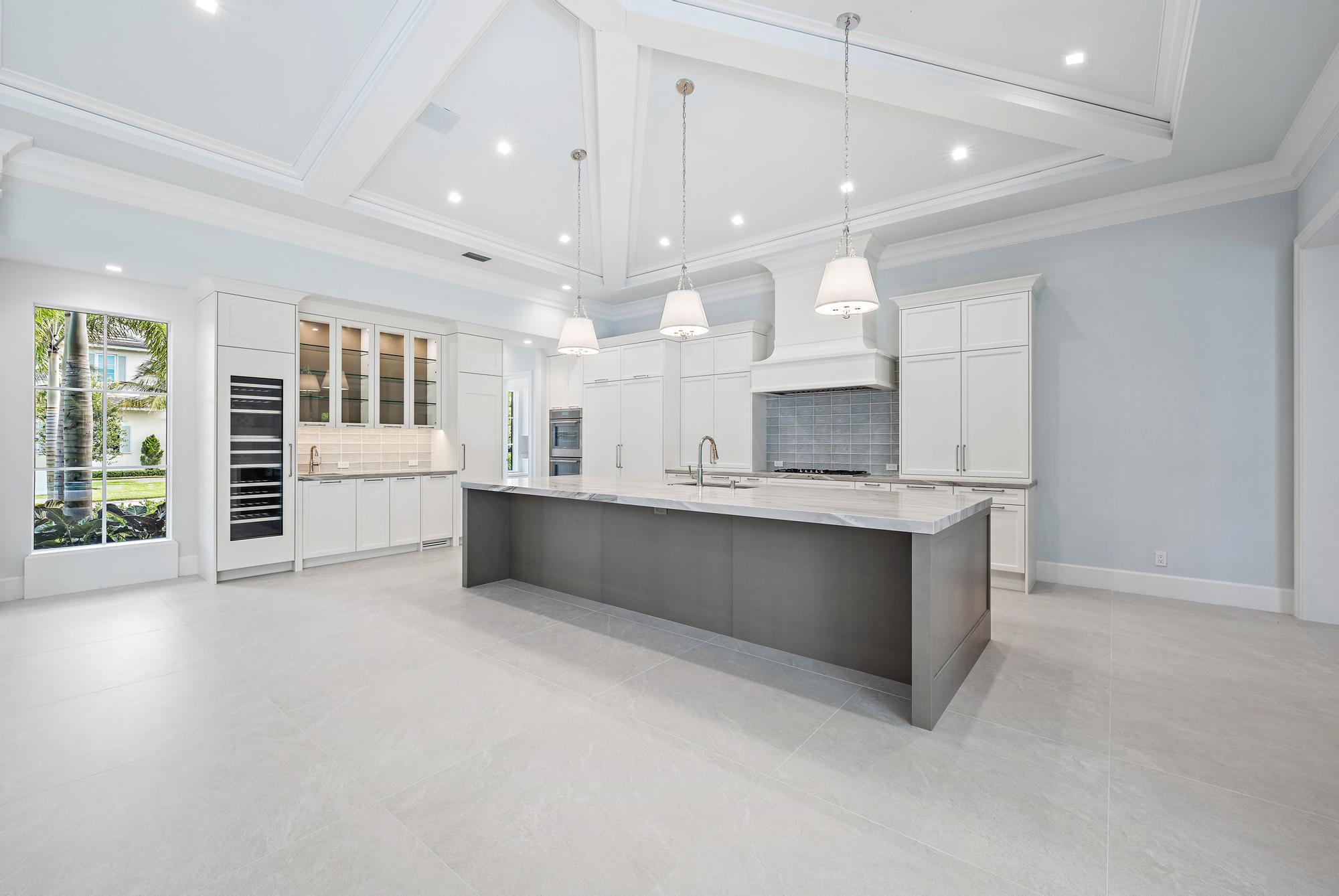 2914 Bluewater Cove Gulf Stream, FL 33483 - Photo 11 of 45 a large white kitchen with a large window and stainless steel appliances