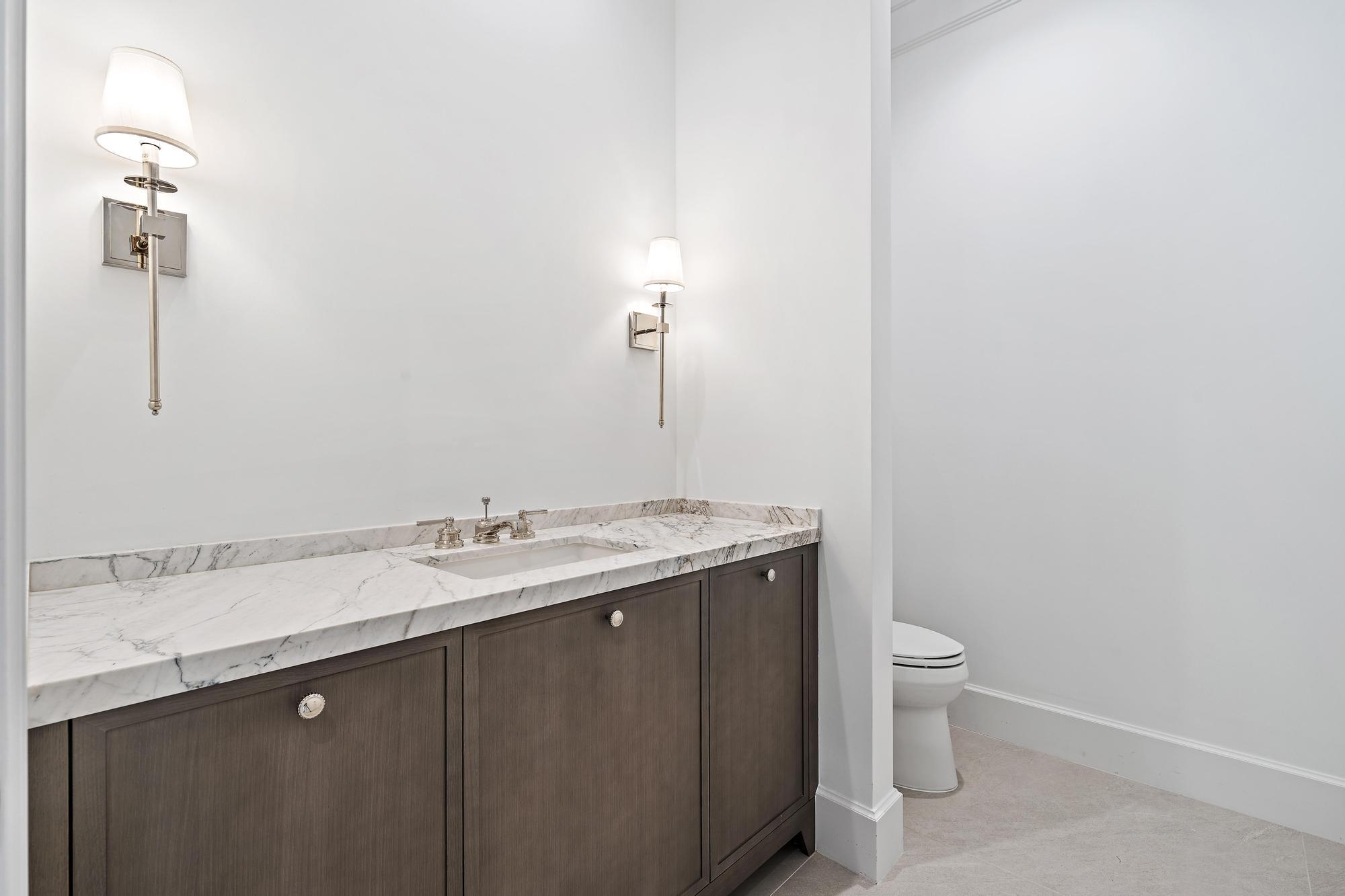 2914 Bluewater Cove Gulf Stream, FL 33483 - Photo 20 of 45 a bathroom with a granite countertop sink a toilet and mirror
