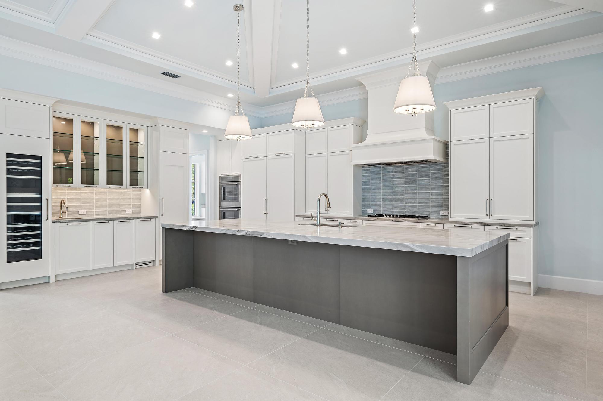 2914 Bluewater Cove Gulf Stream, FL 33483 - Photo 4 of 45 a large kitchen with kitchen island a sink stainless steel appliances and cabinets