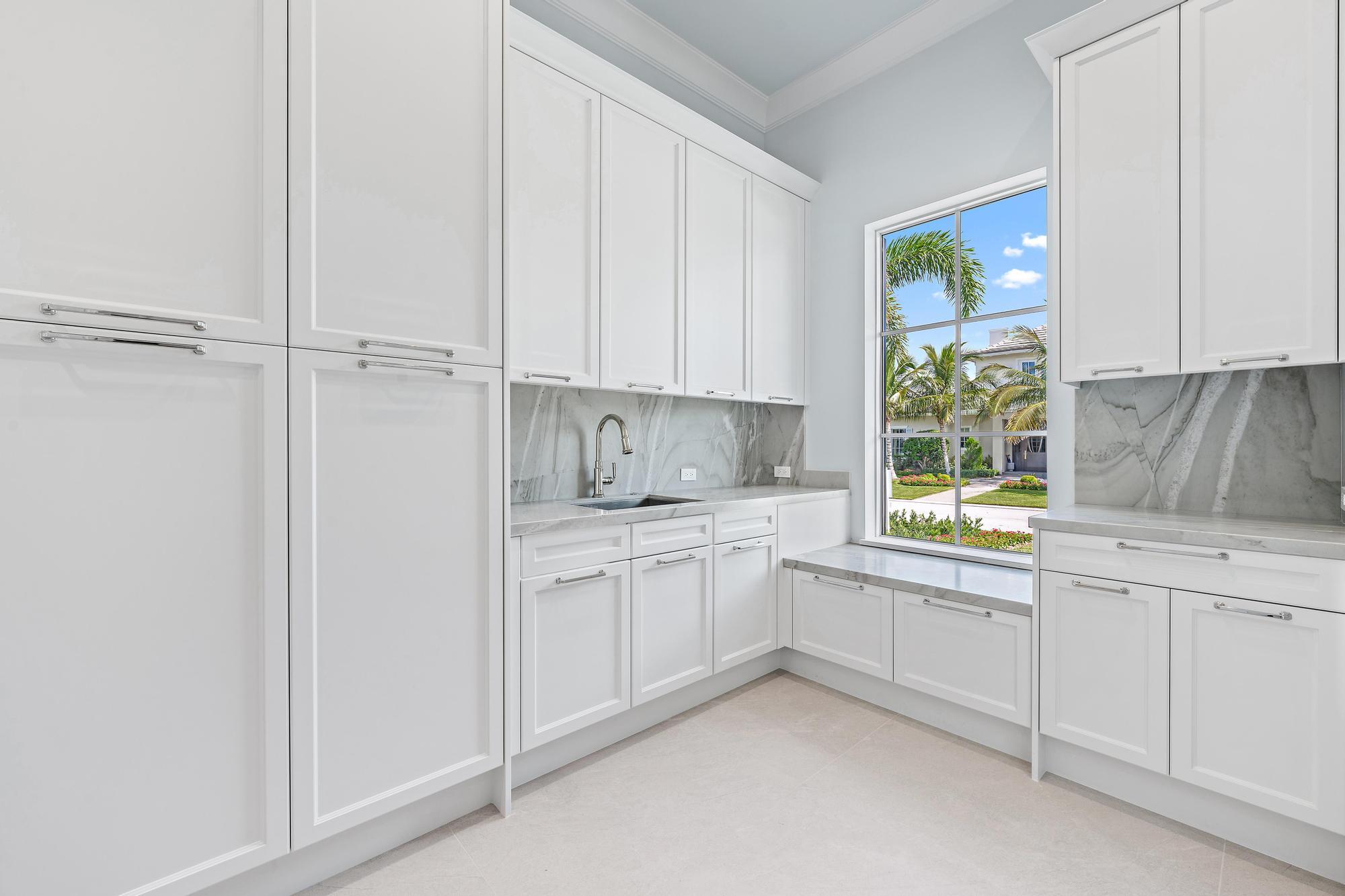 2914 Bluewater Cove Gulf Stream, FL 33483 - Photo 10 of 45 a kitchen with white cabinets and a window