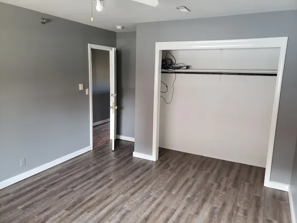 a view of a room with wooden floor and a walk in closet