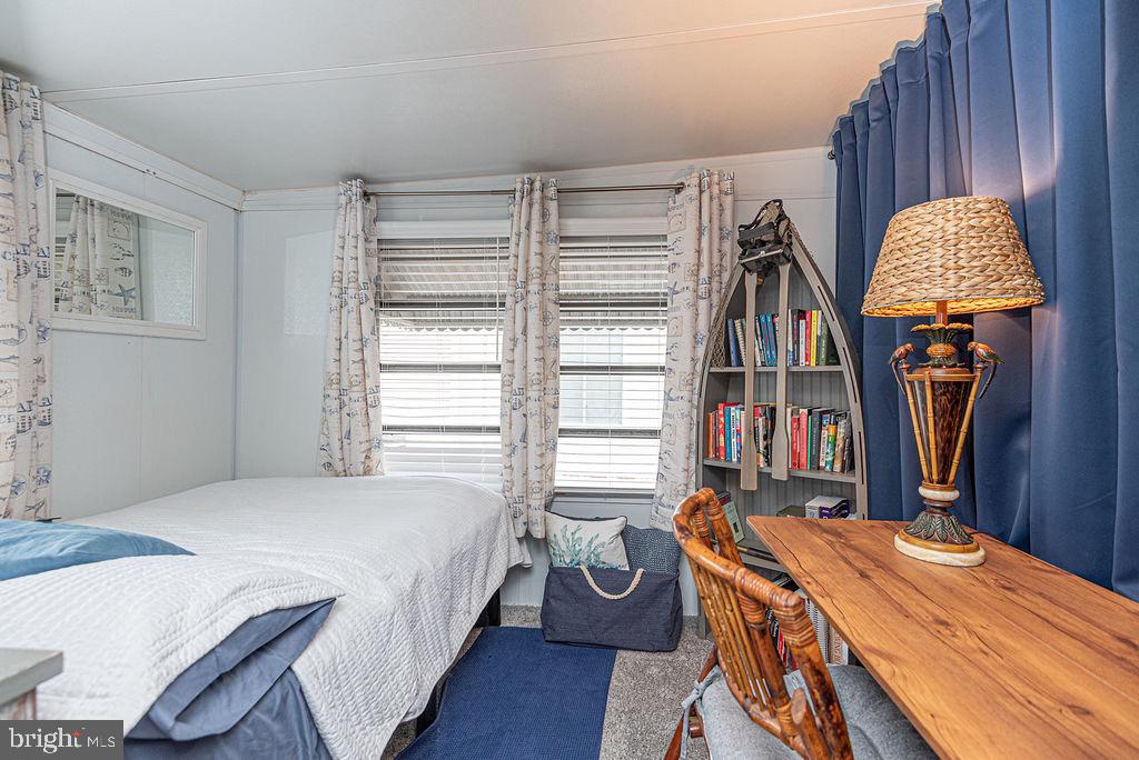 114 Skipjack Circle Berlin, MD 21811 - Photo 21 of 51 a bedroom with a bed a table and a book shelf