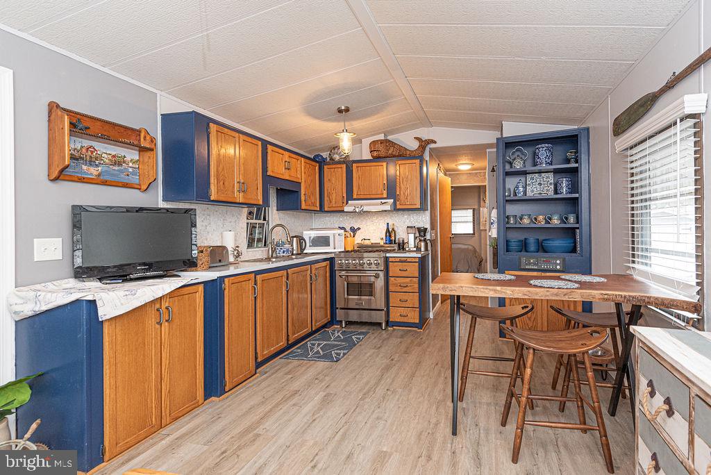 114 Skipjack Circle Berlin, MD 21811 - Photo 29 of 51 a kitchen with stainless steel appliances kitchen island granite countertop a stove a sink dishwasher and a refrigerator