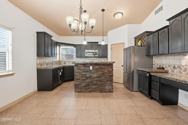 a kitchen with stainless steel appliances granite countertop a stove top oven a refrigerator a sink and dishwasher