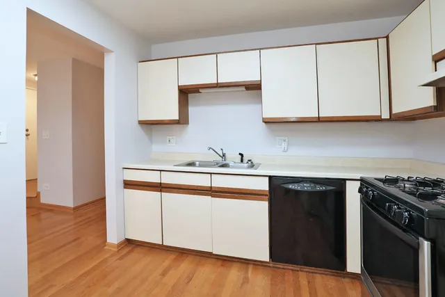 a kitchen with granite countertop wooden cabinets and a stove top oven