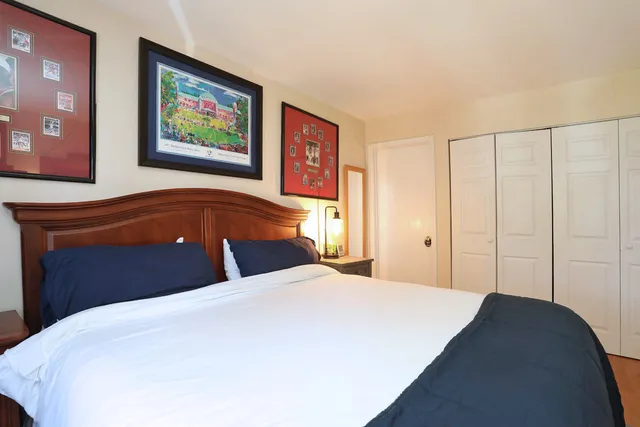 a bedroom with a bed and painting on the wall