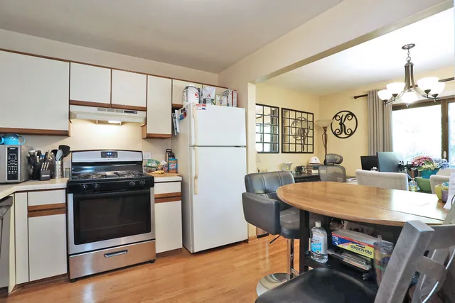 a kitchen with refrigerator cabinets and wooden floor