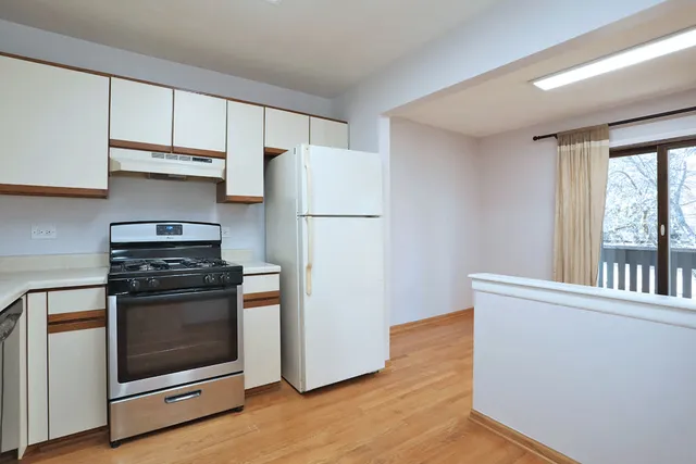 a kitchen with a stove a refrigerator and a window