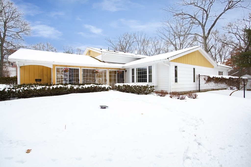 a view of a white house with a yard covered in snow