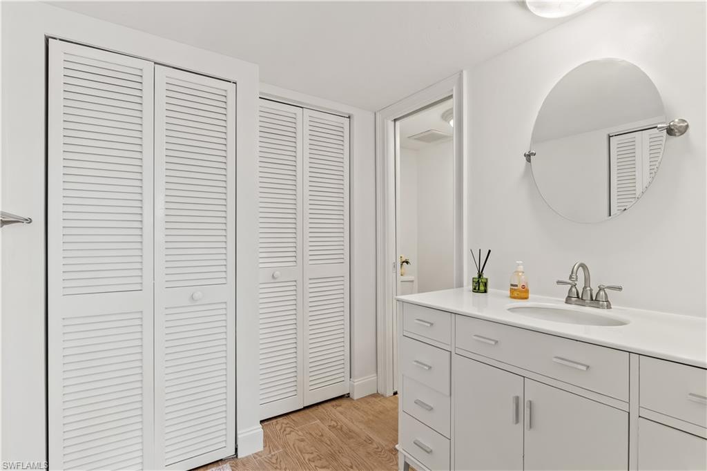 1020 Palm View Drive, Unit C302 Naples, FL 34110 - Photo 14 of 19 Bathroom with a closet, vanity, and light wood-style flooring