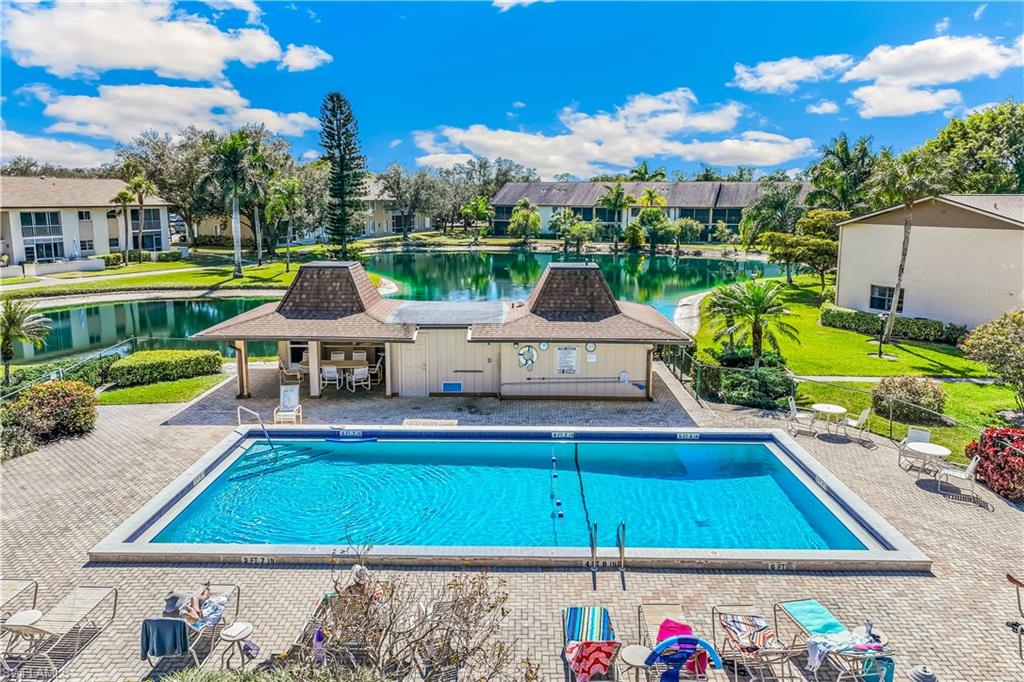 1020 Palm View Drive, Unit C302 Naples, FL 34110 - Photo 15 of 19 Community pool featuring a patio area, a water view, and a yard