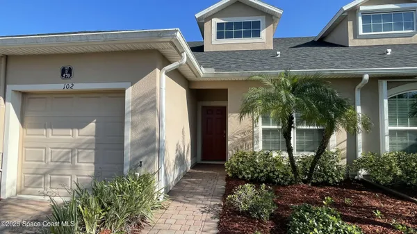 a front view of a house with plants