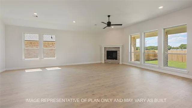 a view of an empty room with a window and a kitchen
