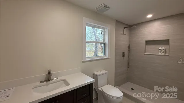 an empty room with wooden floor and a ceiling fan