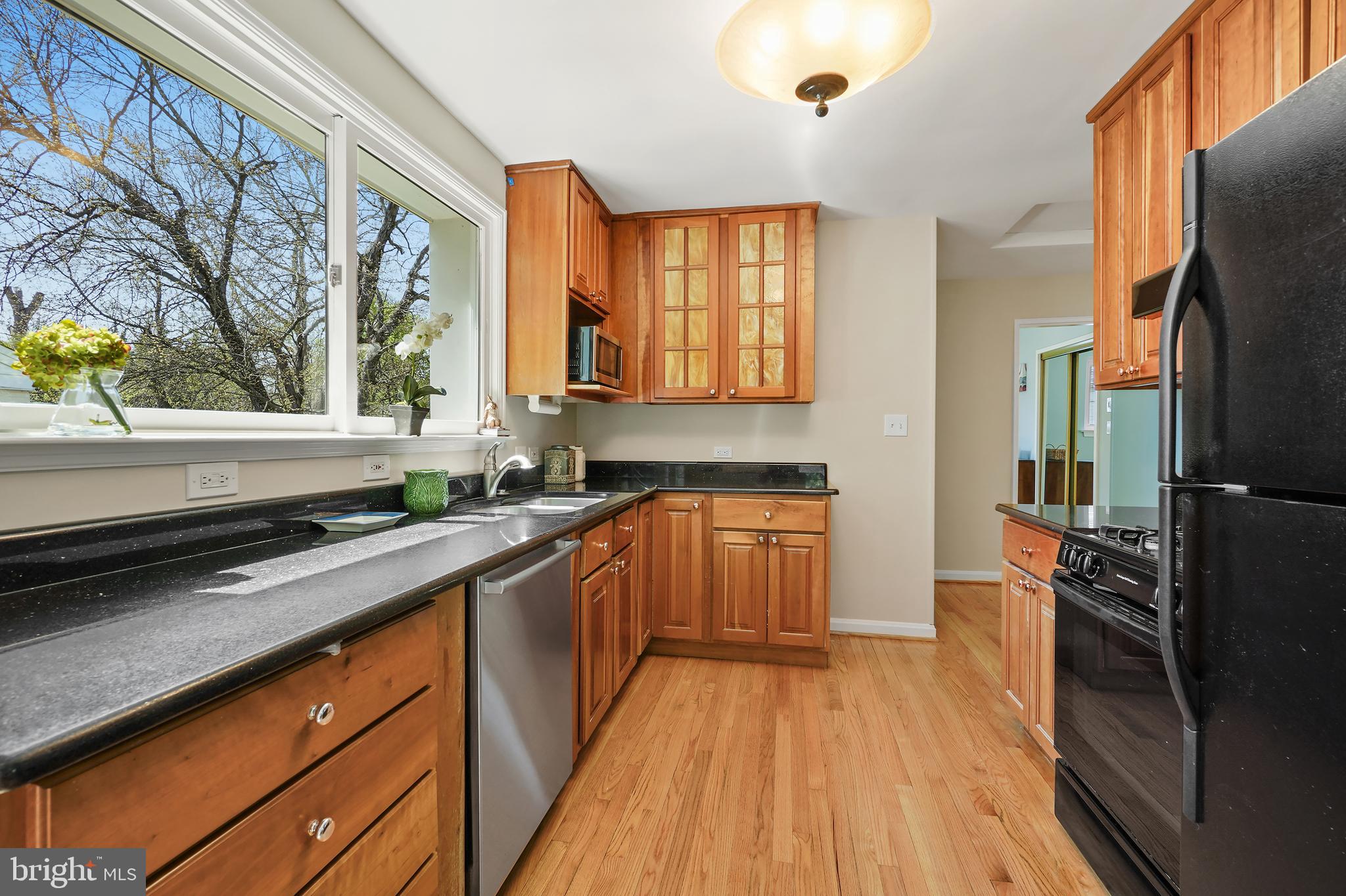 8600 Grubb Road Chevy Chase, MD 20815 - Photo 13 of 36 a kitchen with stainless steel appliances wooden floor sink and wooden cabinets