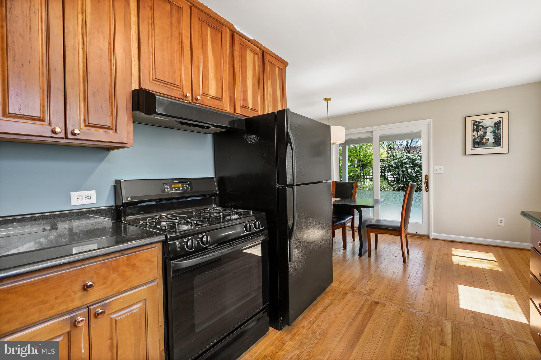 8600 Grubb Road Chevy Chase, MD 20815 - Photo 15 of 36 a kitchen with granite countertop wooden floors and stainless steel appliances