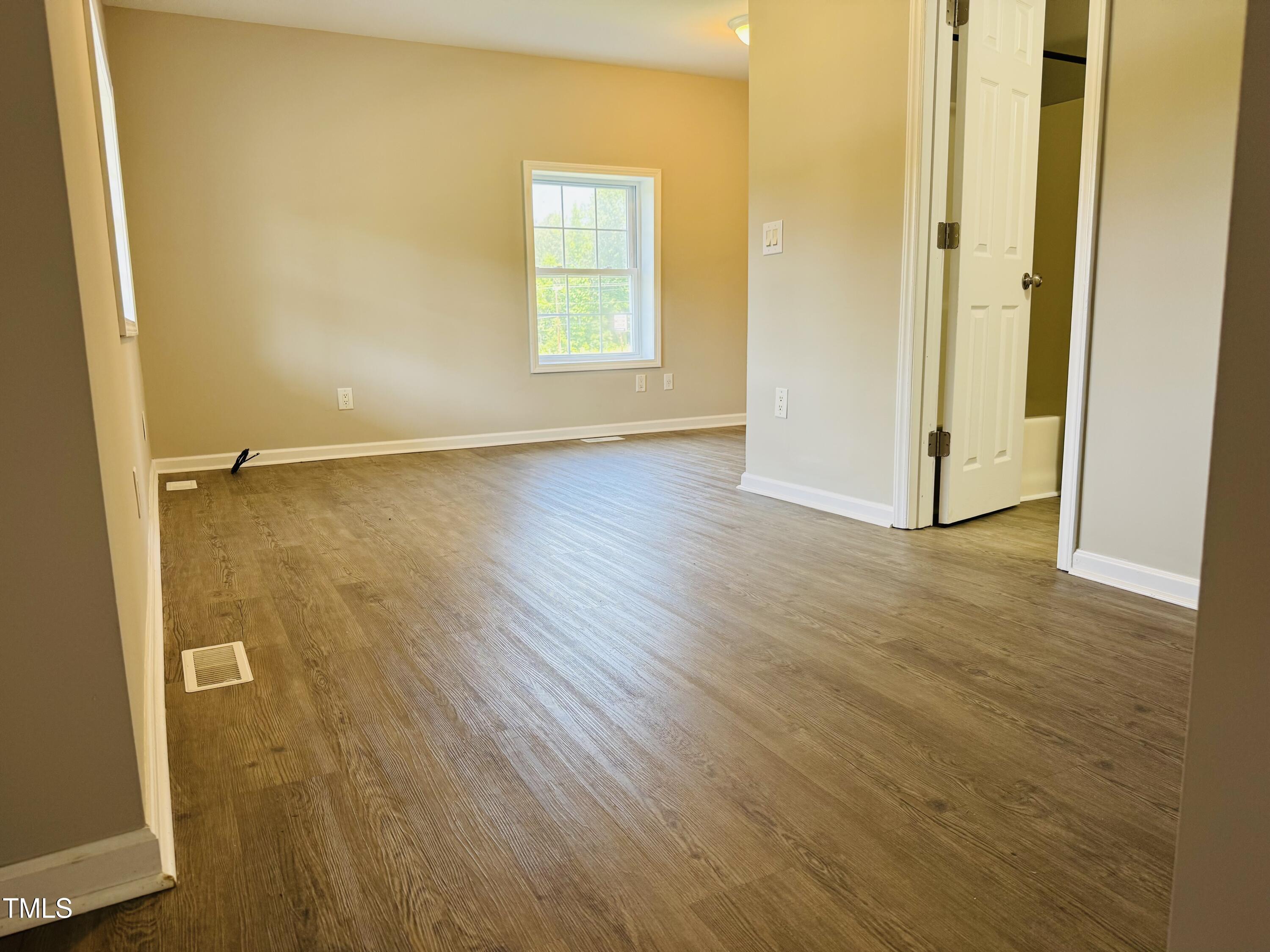 527 Forrest Street Hillsborough, NC 27278 - Photo 6 of 44 an empty room with wooden floor and windows