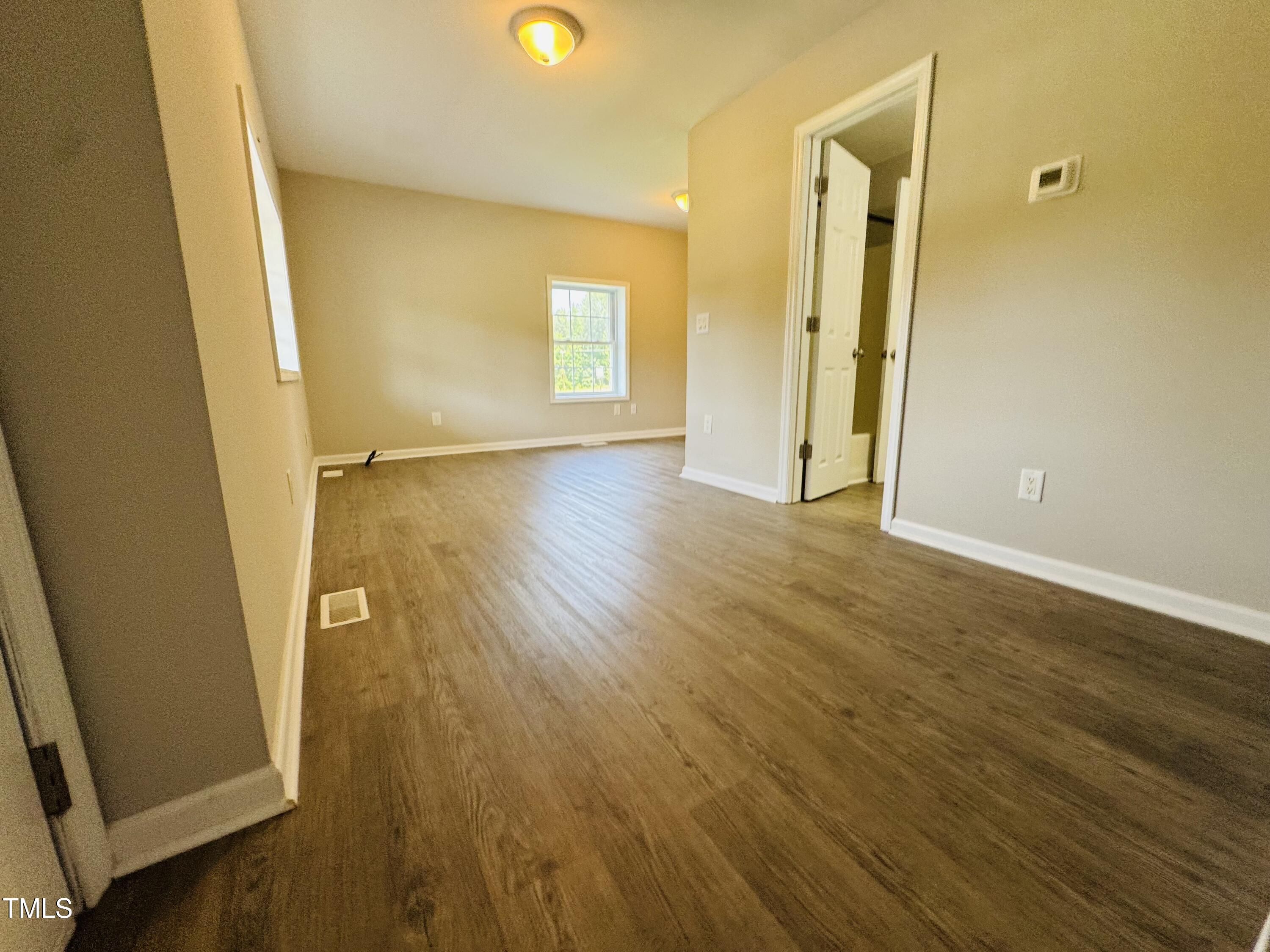 527 Forrest Street Hillsborough, NC 27278 - Photo 9 of 44 an empty room with wooden floor and windows