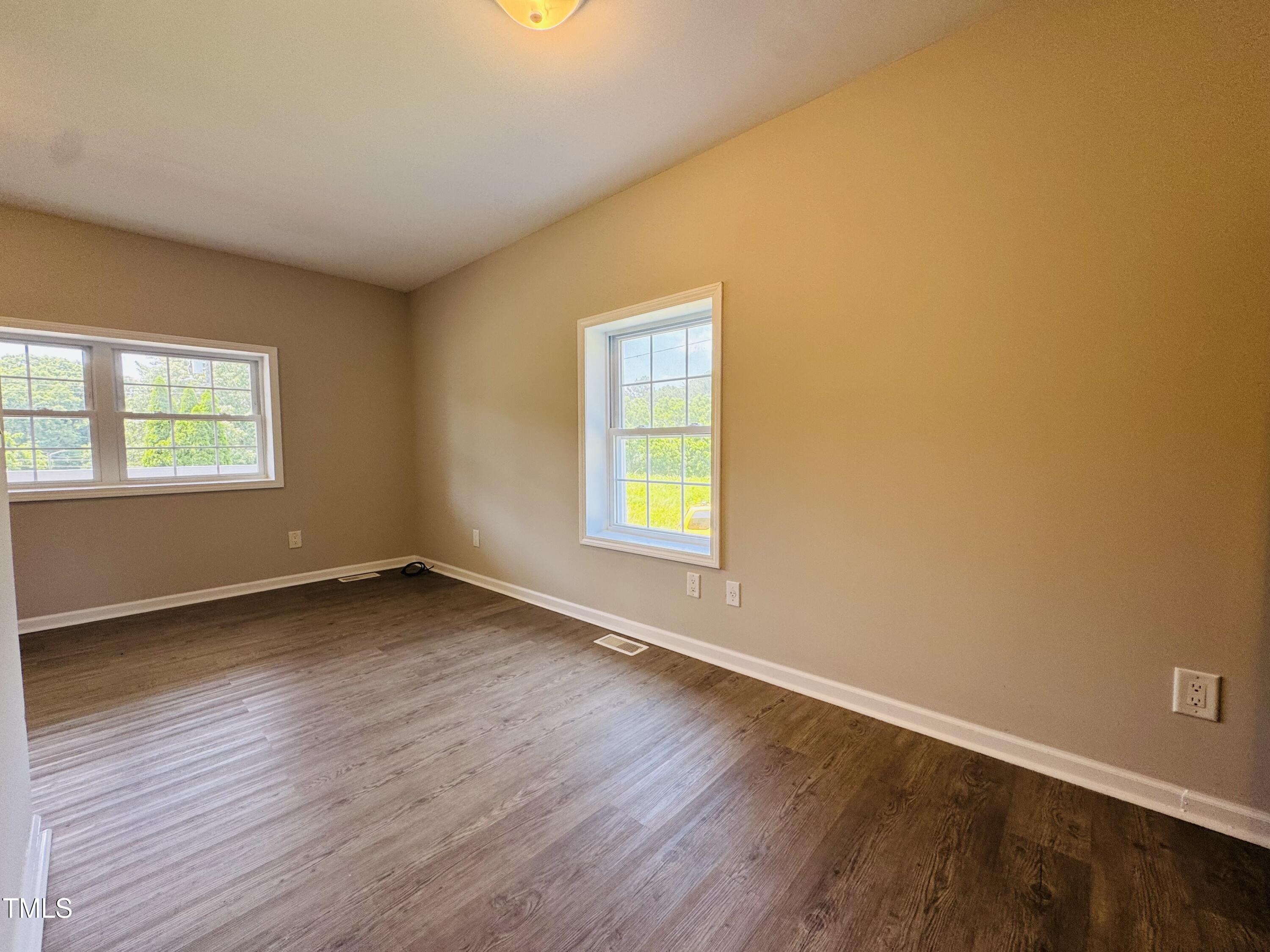 527 Forrest Street Hillsborough, NC 27278 - Photo 17 of 44 a view of an empty room with wooden floor and a window