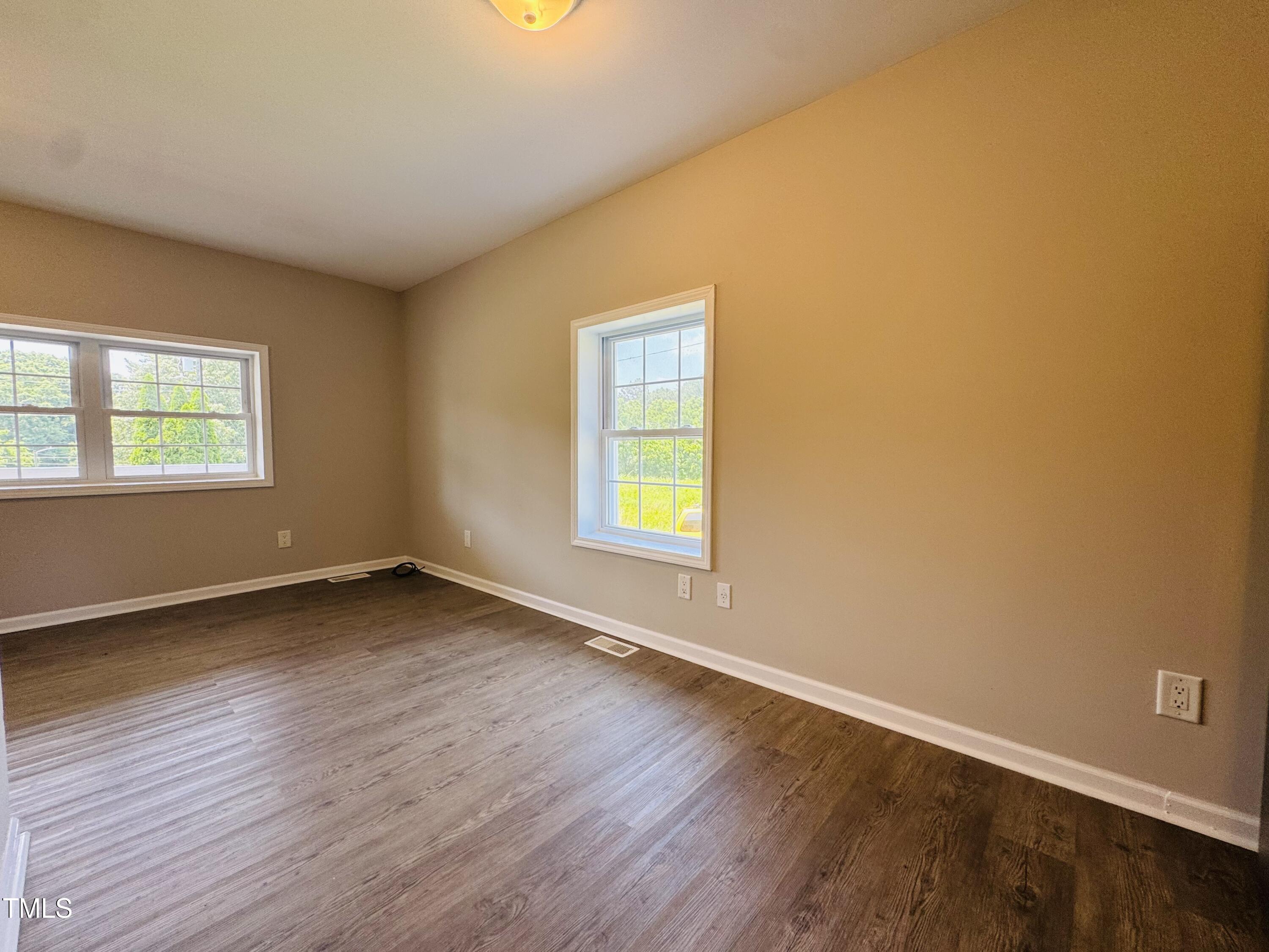 527 Forrest Street Hillsborough, NC 27278 - Photo 18 of 44 a view of an empty room with wooden floor and a window