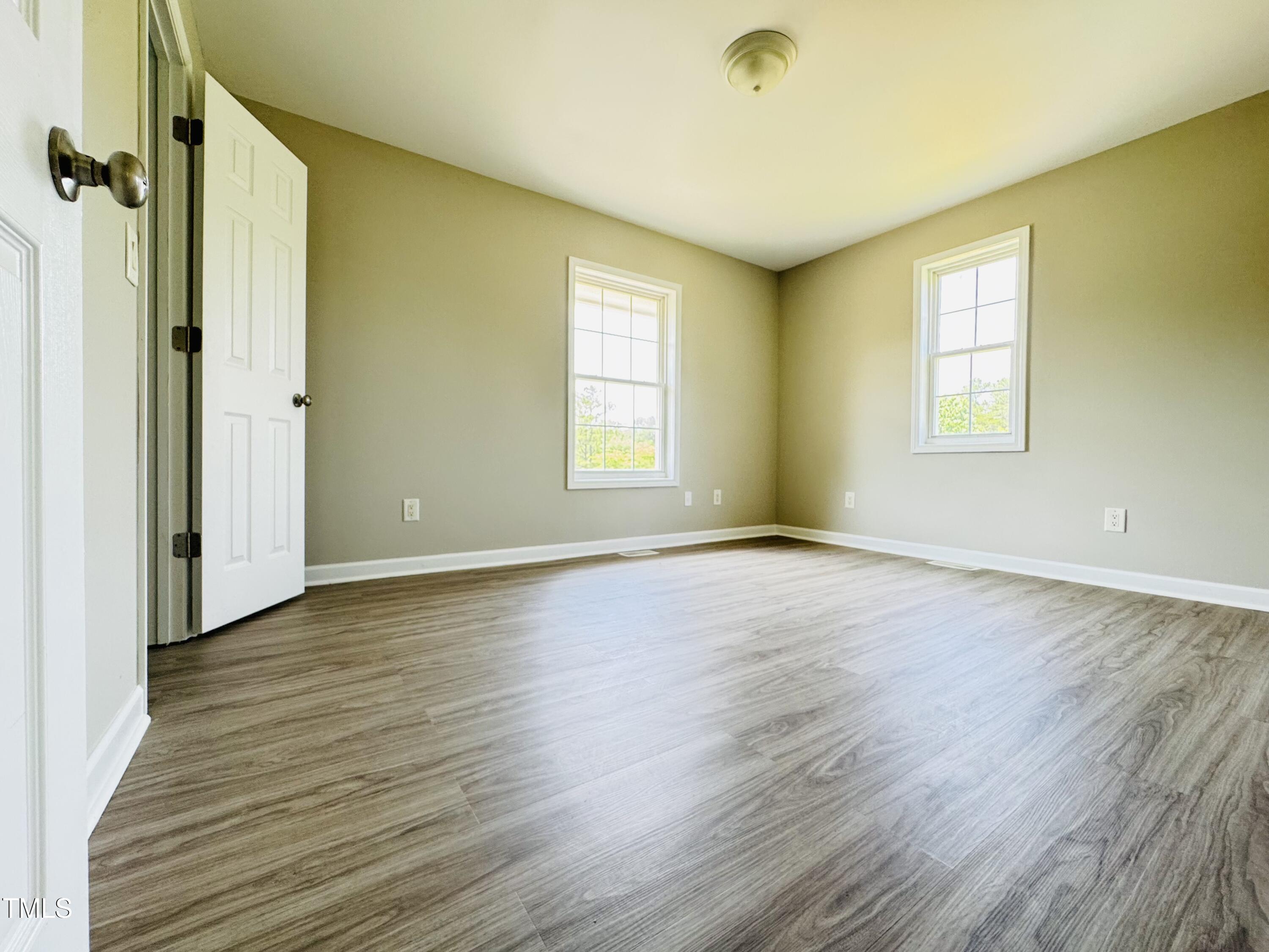527 Forrest Street Hillsborough, NC 27278 - Photo 19 of 44 an empty room with wooden floor and windows