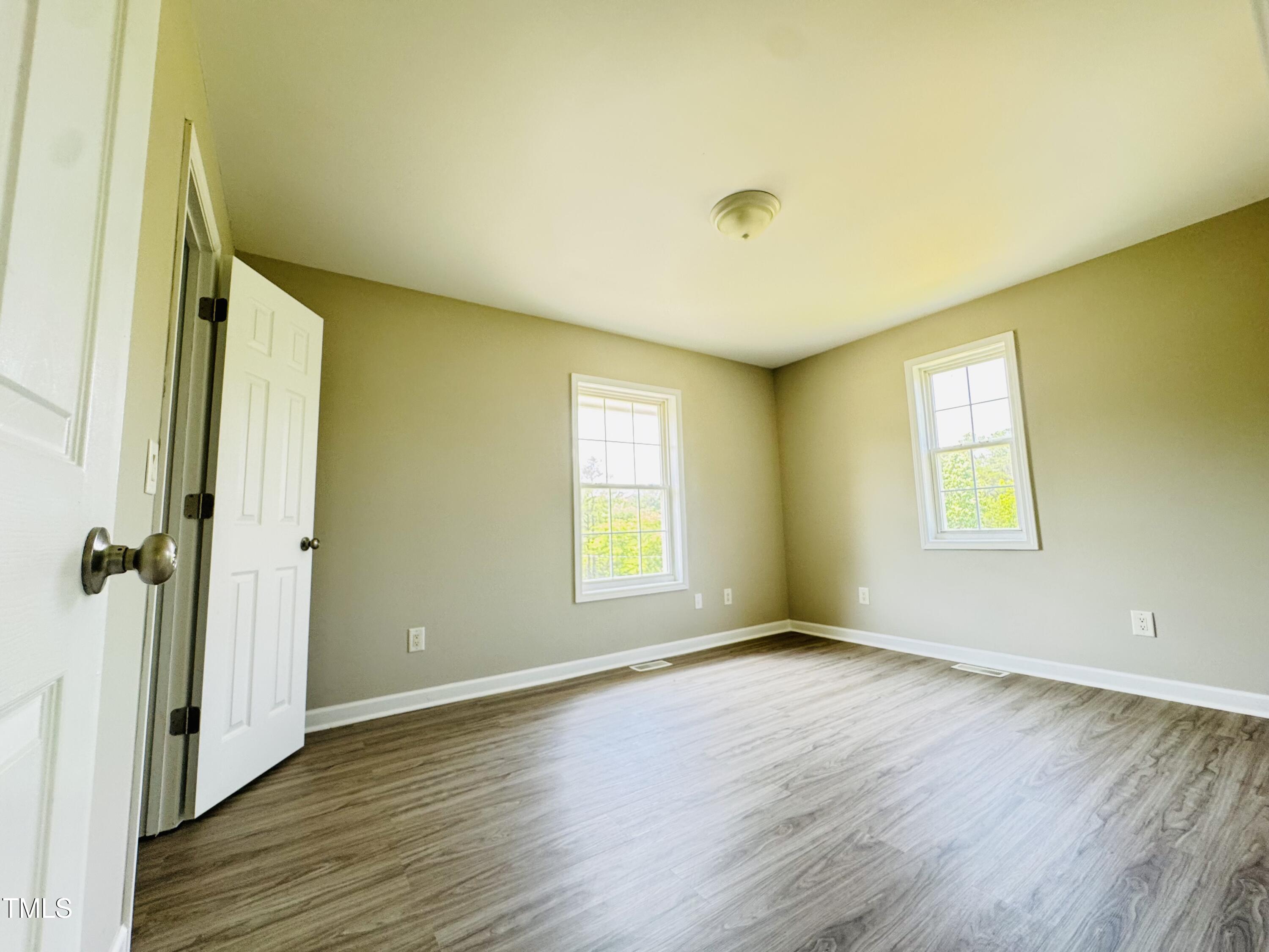 527 Forrest Street Hillsborough, NC 27278 - Photo 21 of 44 a view of an empty room with wooden floor and a window