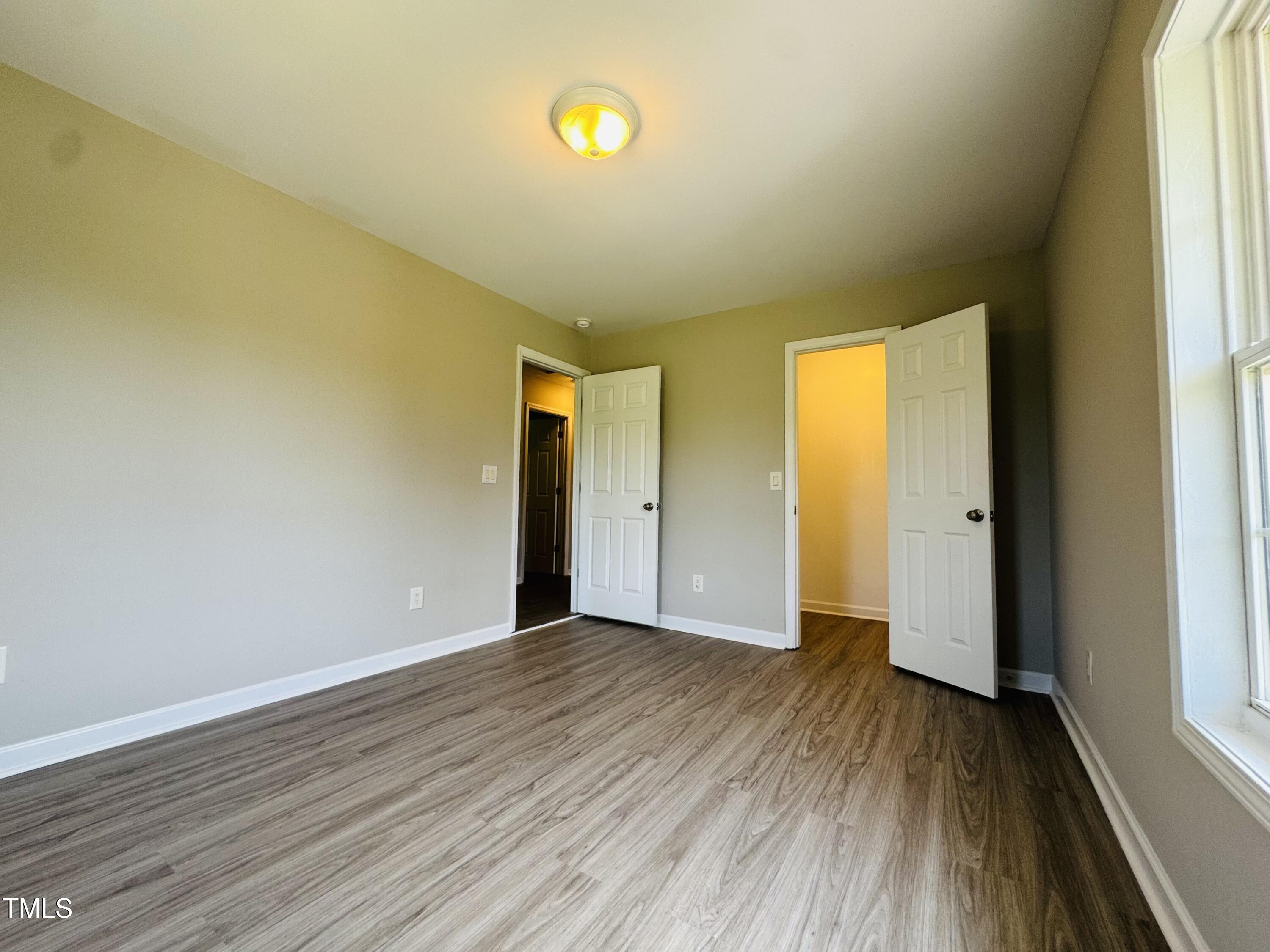 527 Forrest Street Hillsborough, NC 27278 - Photo 26 of 44 a view of an empty room with wooden floor and a window