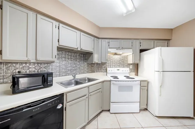 a kitchen with appliances a sink and cabinets