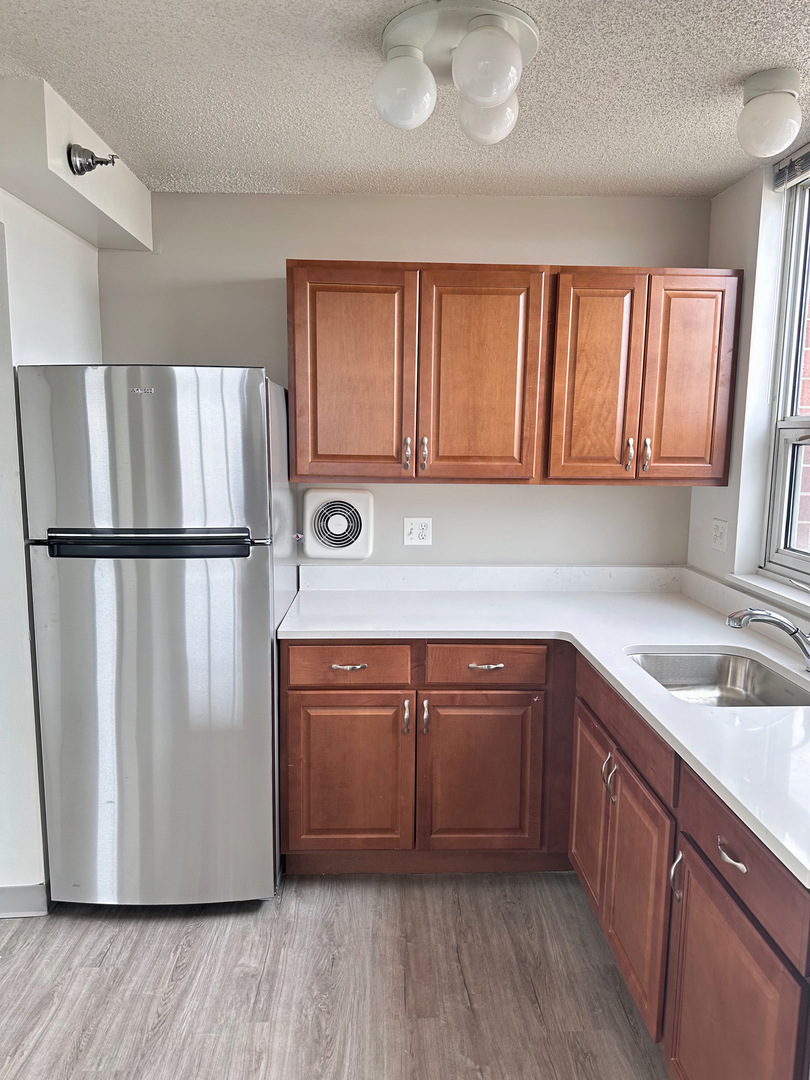 8975 West Golf Road, Unit 321 Niles, IL 60714 - Photo 2 of 10 a kitchen with stainless steel appliances granite countertop a refrigerator sink and cabinets