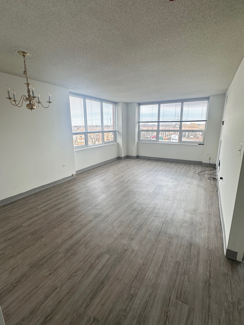 8975 West Golf Road, Unit 321 Niles, IL 60714 - Photo 4 of 10 wooden floor in an empty room with a window