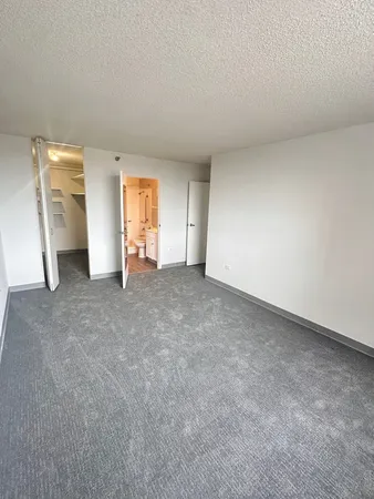 an empty room with a window and a kitchen