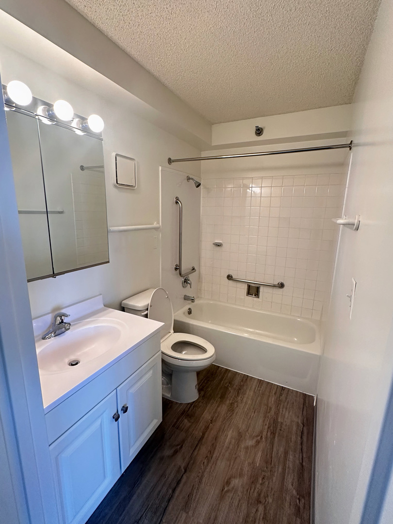 8975 West Golf Road, Unit 321 Niles, IL 60714 - Photo 7 of 10 a bathroom with a double vanity sink toilet mirror and bathtub