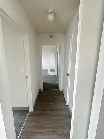 a view of a hallway with wooden floor
