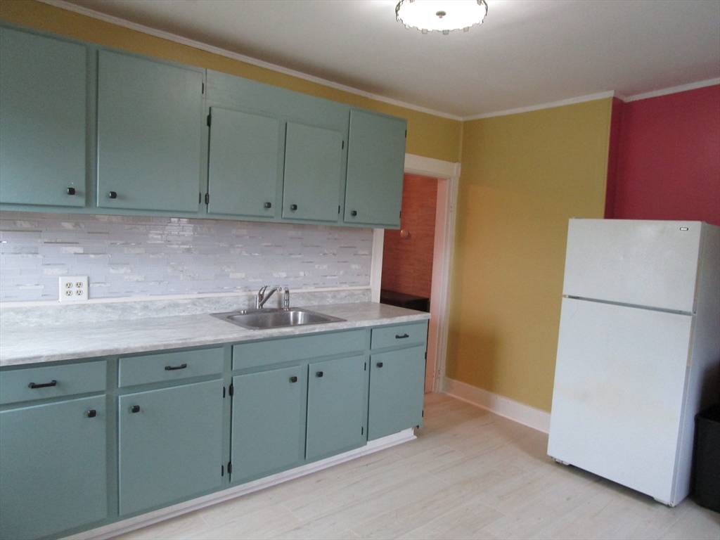 226 Irving Street, Unit 2 Framingham, MA 01702 - Photo 2 of 10 a kitchen with a sink a refrigerator and cabinets