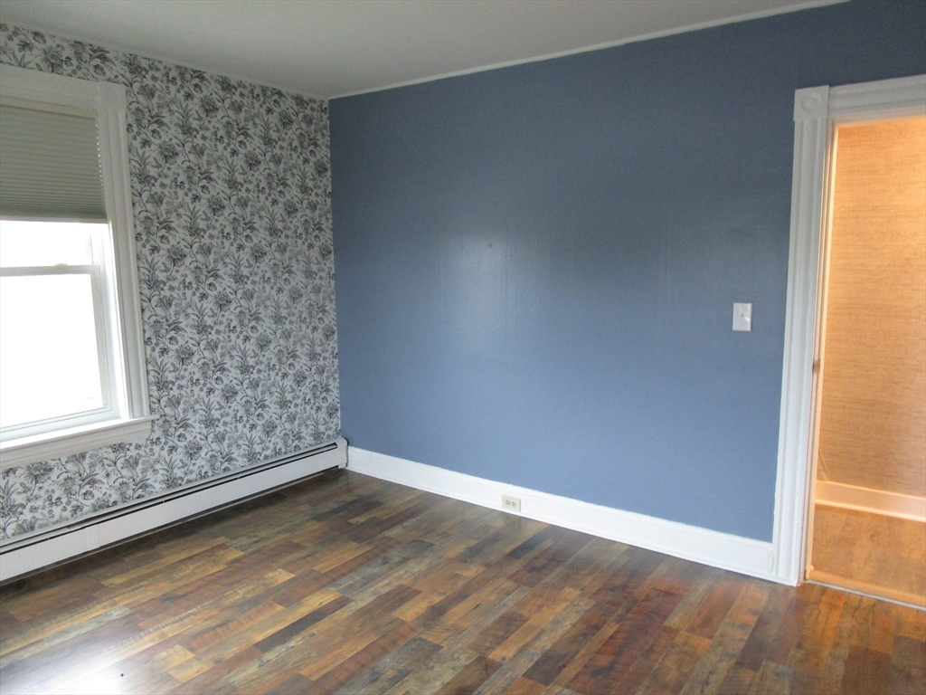 226 Irving Street, Unit 2 Framingham, MA 01702 - Photo 8 of 10 an empty room with wooden floor and windows