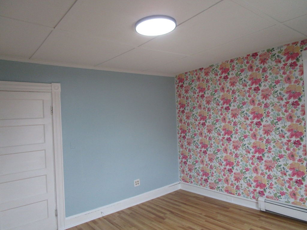 226 Irving Street, Unit 2 Framingham, MA 01702 - Photo 10 of 10 a view of an empty room with wooden floor and a window